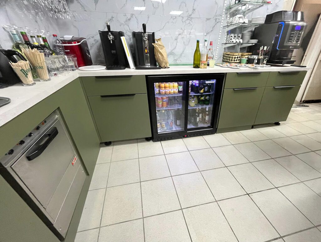 Espace bar et cuisine du tabac presse Le Chiniacus à Cheny, aménagé par Sudexpo : mobilier vert kaki sur mesure, tireuse à bière, réfrigérateur vitré et machine à café, crédence effet marbre